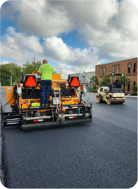 Professional paving crew operating asphalt paver and roller for smooth commercial blacktop surface in Delaware, Ohio.