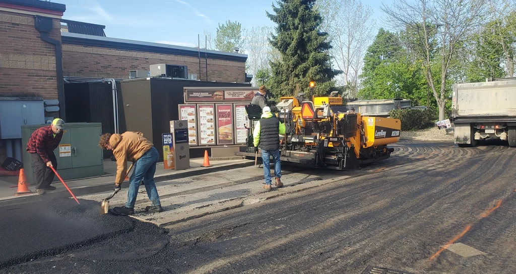 Paving crew installing new asphalt near the Wendy’s drive-thru during a phased commercial parking lot repaving project.
