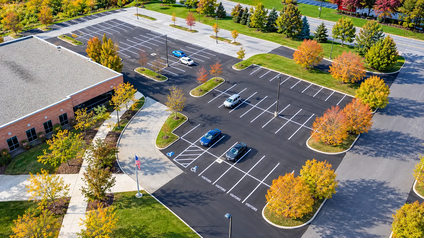 Aerial view of a newly paved and striped office parking lot with accessible and visitor spaces