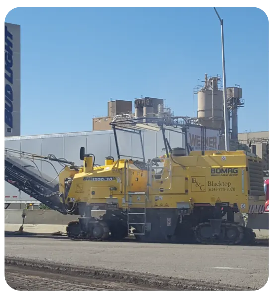 Commercial asphalt milling machine removing damaged pavement during a Columbus parking lot restoration project.